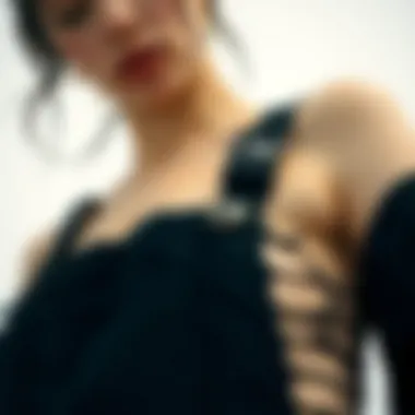 A close-up of the intricate detailing on black ripped overalls against a minimalist backdrop.