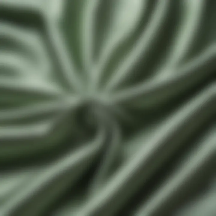 Close-up of the smooth texture of sage green satin fabric